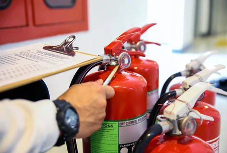 Person inspecting a fire extinguisher 